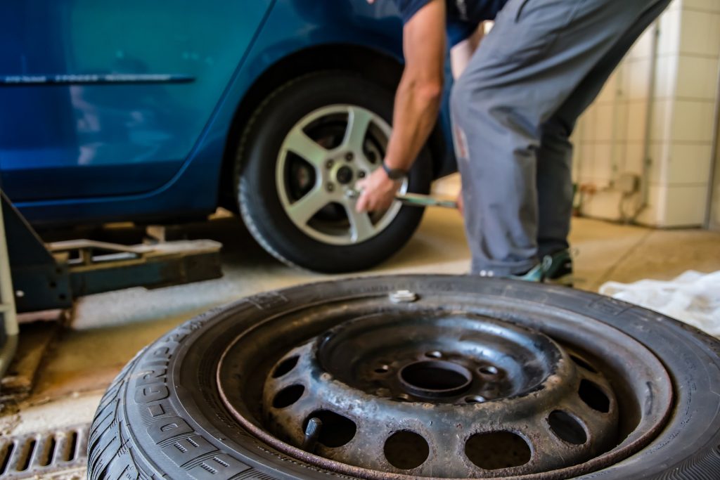 man changing a tire on a car